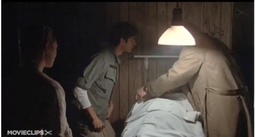 Tugs front of pants while bending down Goldblum